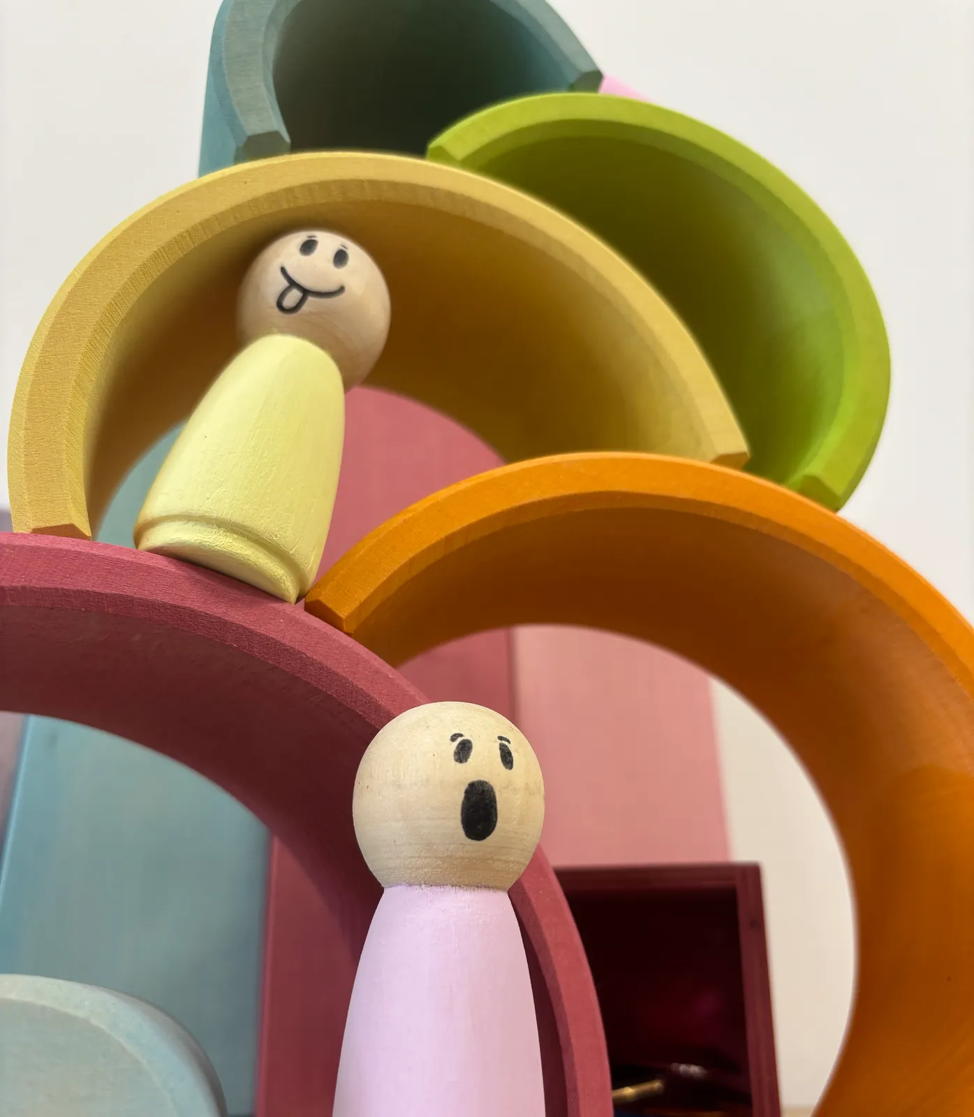 Twee houten poppetjes in een regenboogtoren in de spelkamer
