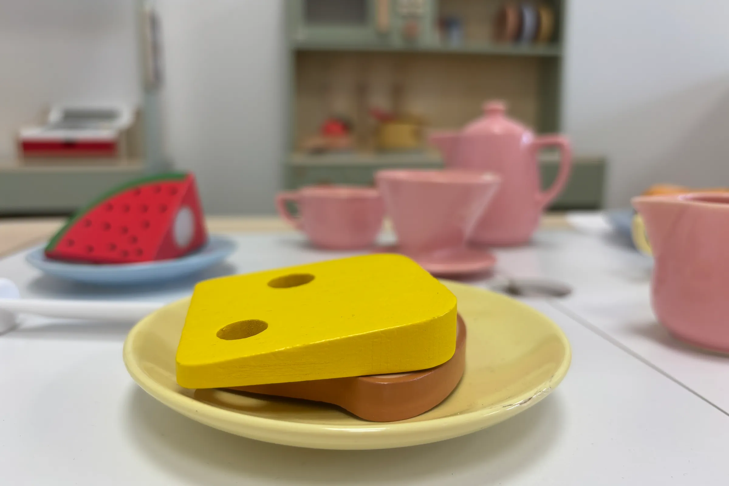 Een gedekte speelgoedtafel met een boterham met kaas